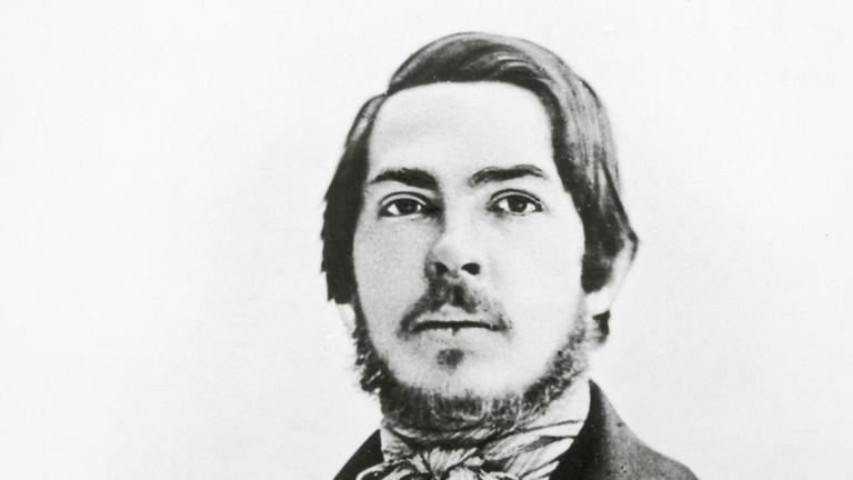 eine schwarzweiße Photographie zeigt Friedrich Engels um 1840 in schwatrzem Mantel mit breitem Revers und hellem Halstuch eine schwarzweiße Photographie zeigt Friedrich Engels um 1840 in schwatrzem Mantel mit breitem Revers und hellem Halstuch