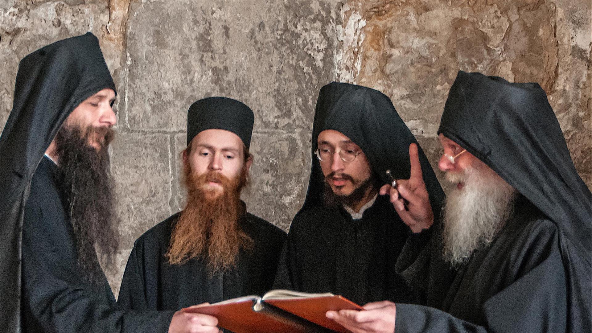 Für die Mönche im Deutschen Orthodoxen Dreifaltigkeits Kloster Buchhagen ist der Choralgesang auch geistige Übung. Vier Mönche mit schwarzen Kopfbedeckungen stehen im Halbkreis um eine Noten-Partitur, der Abt steht auf der rechten Seite und hebt den Finger, drei der Männer tragen lange Bärte Für die Mönche im Deutschen Orthodoxen Dreifaltigkeits Kloster Buchhagen ist der Choralgesang auch geistige Übung. Vier Mönche mit schwarzen Kopfbedeckungen stehen im Halbkreis um eine Noten-Partitur, der Abt steht auf der rechten Seite und hebt den Finger, drei der Männer tragen lange Bärte