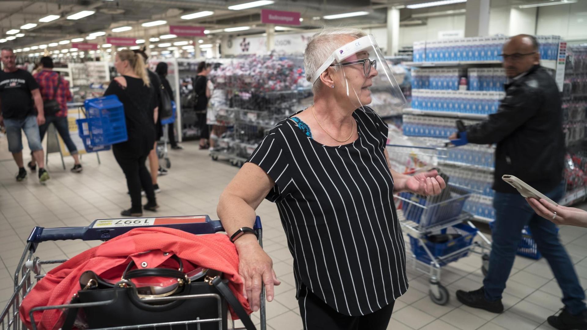 In einem Göteburger Supermarkt trägt eine ältere Frau ein Schutzvisier gegen eine mögliche Ansteckung mit dem Corona Virus.|