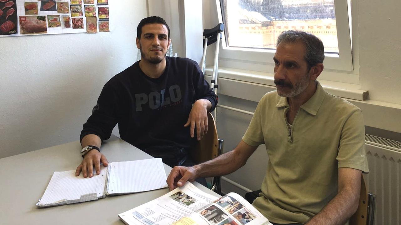 Die beiden Syrer Karim und Mazen sitzen in einer Berliner Sprachschule, um Deutsch zu lernen.