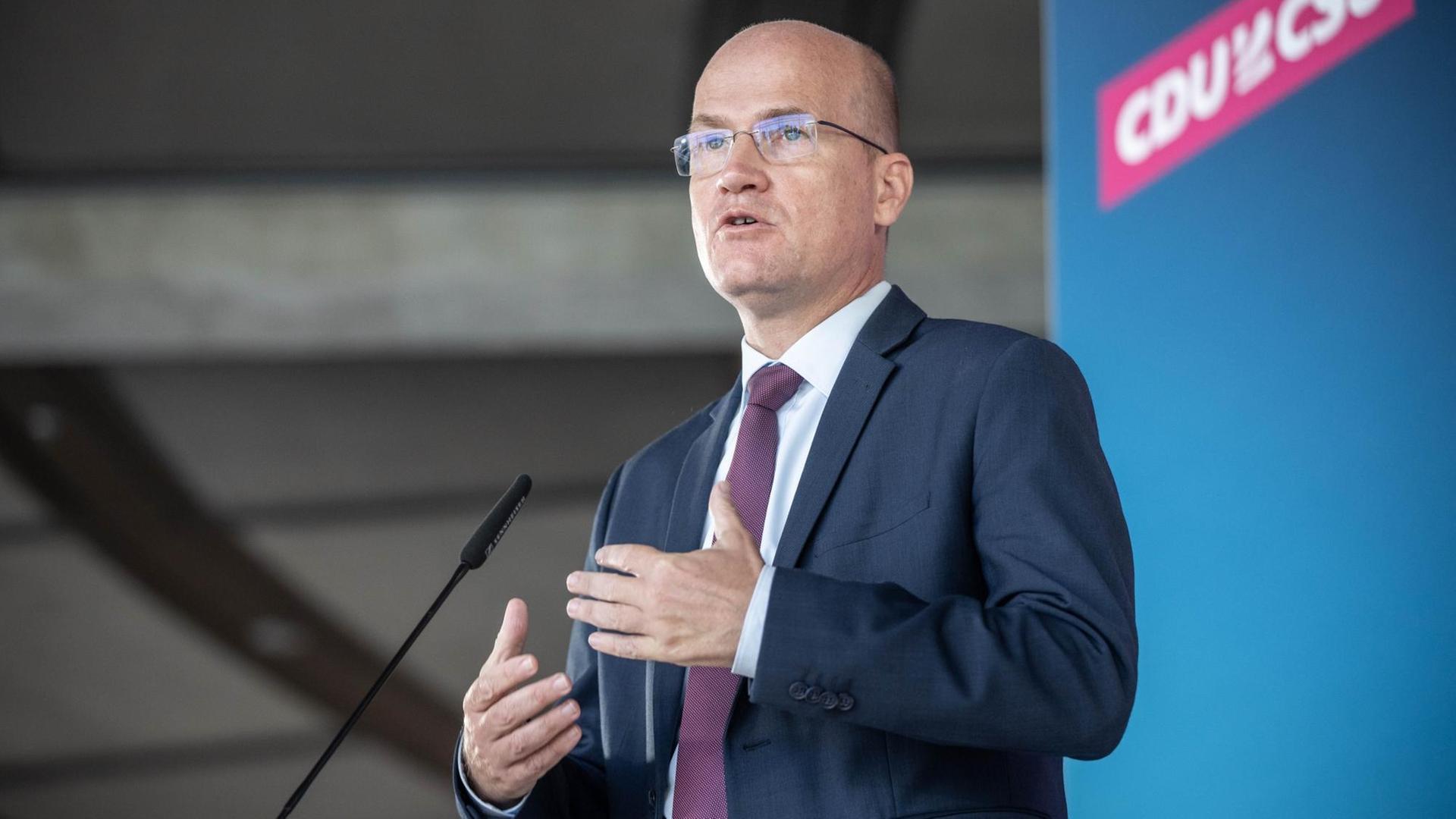Ralph Brinkhaus (CDU) im Bundestag. Er steht vor einer Wand mit dem Logo CDU/CSU. Ralph Brinkhaus (CDU) im Bundestag. Er steht vor einer Wand mit dem Logo CDU/CSU.