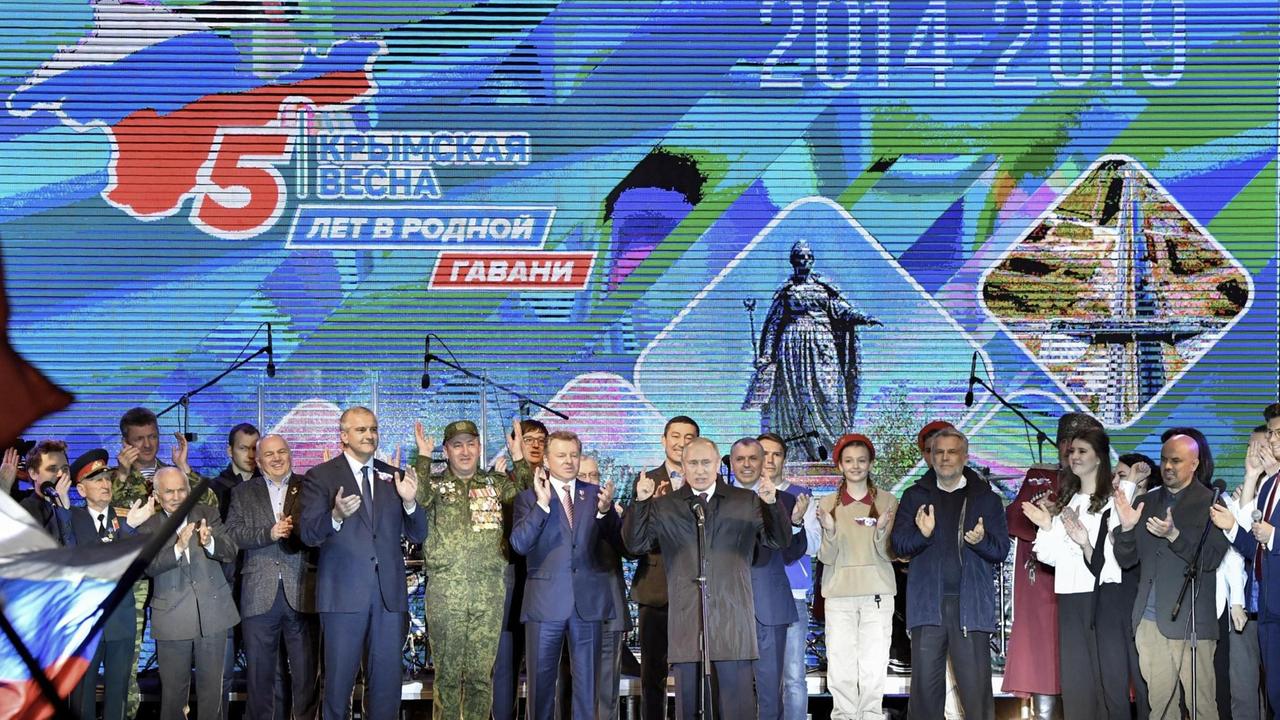 Wladimir Putin (M), Präsident von Russland, gestikuliert bei einem Open-Air-Konzert in Simferopol auf der Krim, aufgenommen im März 2019.