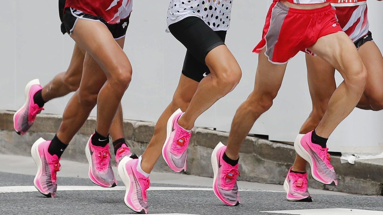 Viele Beine, alle mit dem gleichen, pinken Schuhmodell von Nike am Fuß Viele Beine, alle mit dem gleichen, pinken Schuhmodell von Nike am Fuß