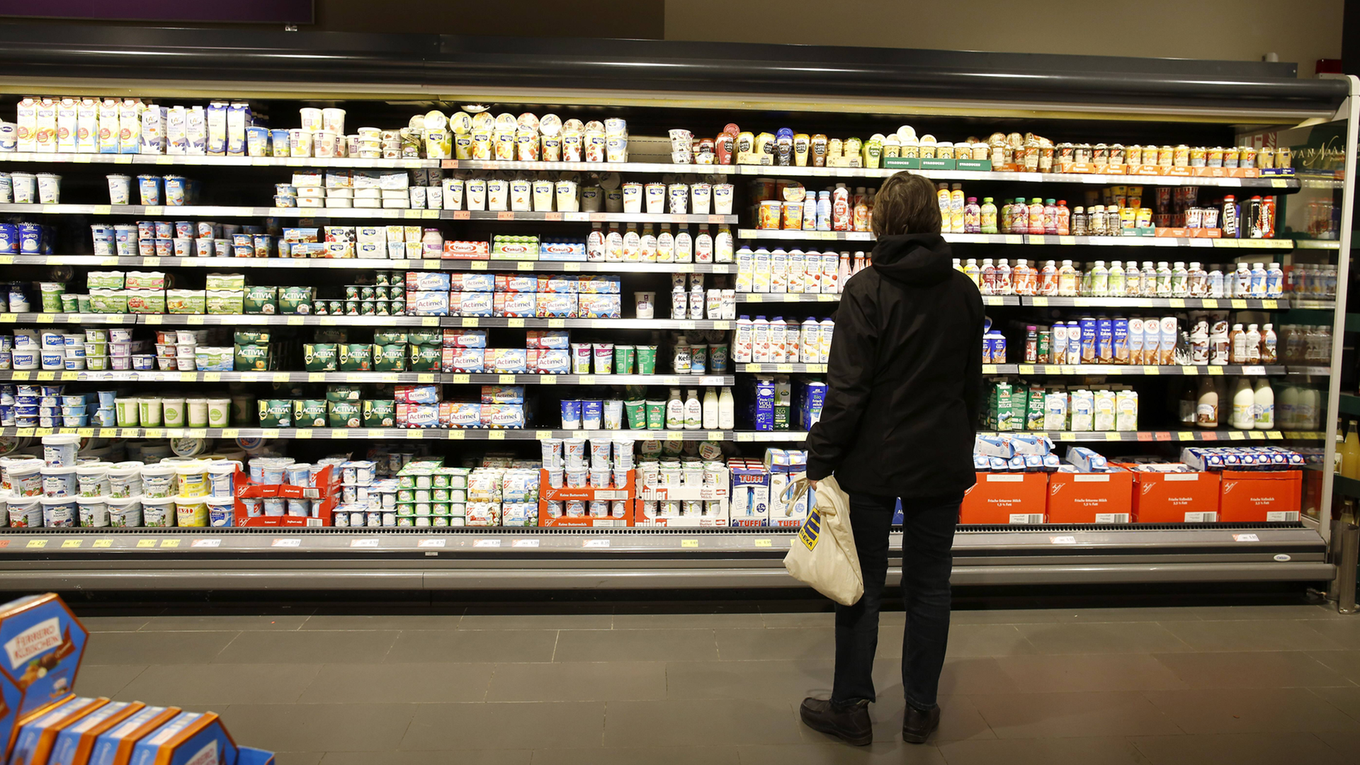 Kunde am Kühlregal im Supermarkt Kunde am Kühlregal im Supermarkt