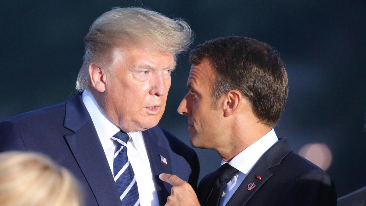US-Präsident Donald Trump steht mit seinem französischen Amtskollgen Emmanuel Macron bei dem G7-Gipfel in Biarritz eng zusammen. Macron spricht in Trumps Ohr und zeigt mit dem Finger auf dessen Brust. US-Präsident Donald Trump steht mit seinem französischen Amtskollgen Emmanuel Macron bei dem G7-Gipfel in Biarritz eng zusammen. Macron spricht in Trumps Ohr und zeigt mit dem Finger auf dessen Brust.