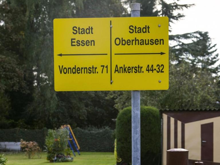 Ein Schild in einem Garten markiert die Stadtgrenze zwischen Essen und Oberhausen.