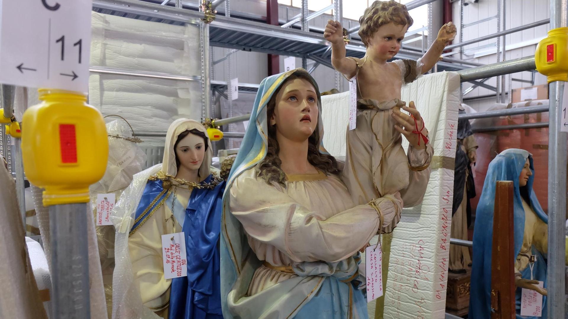 Madonna-Statuen, die aus zerstörten Kirchen in Amatrice und Accumoli geborgen wurden, stehen in einer Lagerhalle in Cittaducale (Italien). Madonna-Statuen, die aus zerstörten Kirchen in Amatrice und Accumoli geborgen wurden, stehen in einer Lagerhalle in Cittaducale (Italien).
