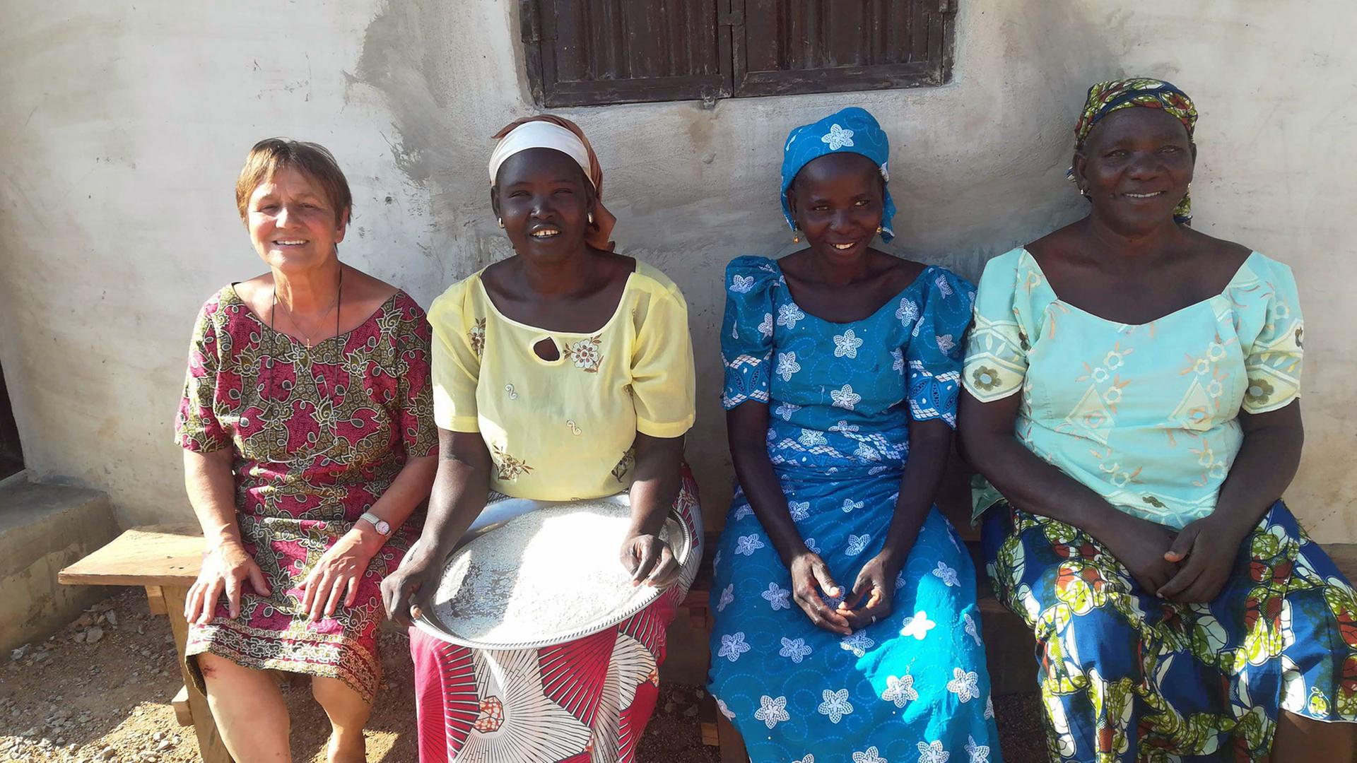 Renate Ellmenreich sitzt im nigerianischen Witwendorf von Widows Care mit Frauen vor der Schulküche. Renate Ellmenreich sitzt im nigerianischen Witwendorf von Widows Care mit Frauen vor der Schulküche.