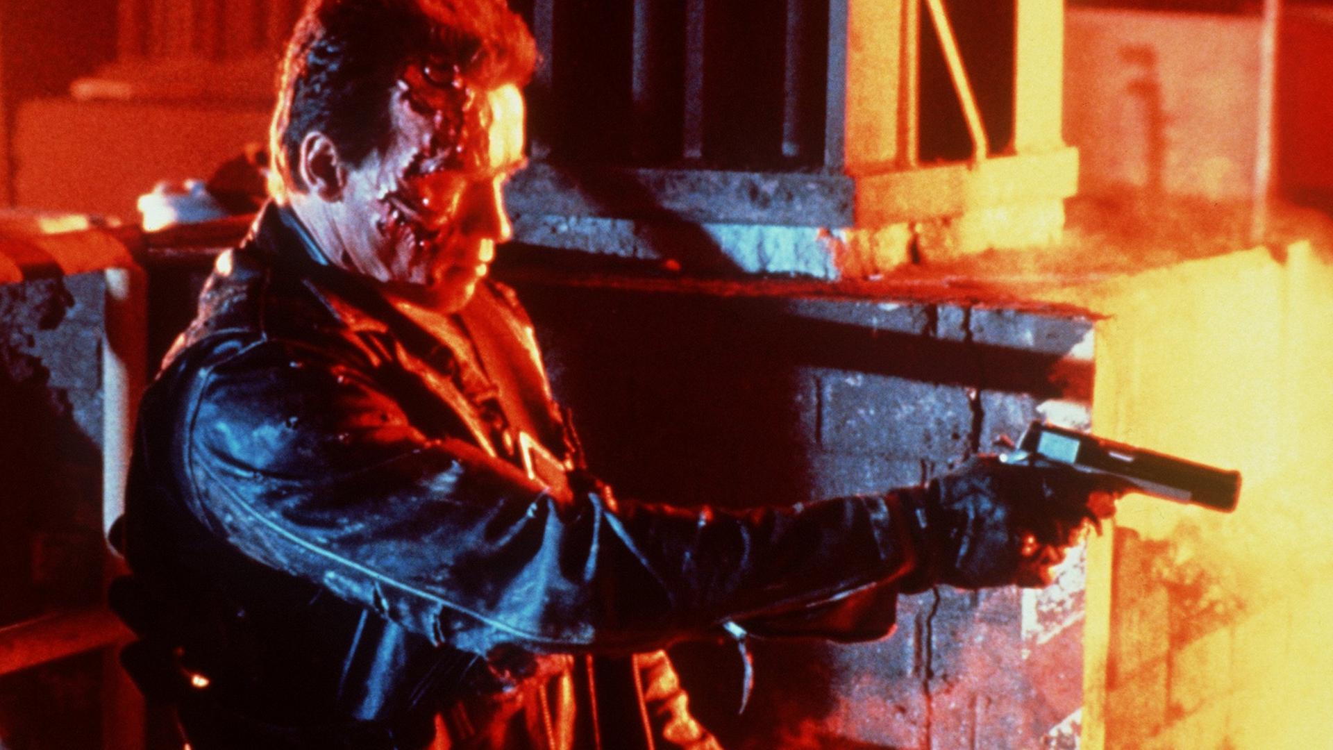Arnold Schwarzenegger in einer Filmszene aus "Terminator ", umgeben von Feuer, schießend Arnold Schwarzenegger in einer Filmszene aus "Terminator ", umgeben von Feuer, schießend