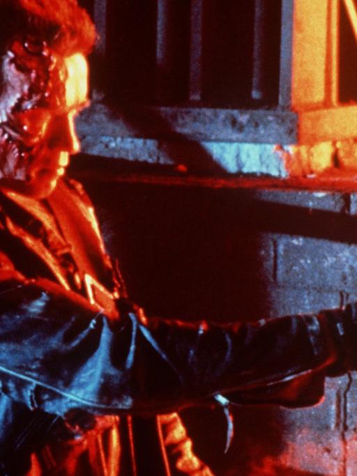 Arnold Schwarzenegger in einer Filmszene aus "Terminator ", umgeben von Feuer, schießend