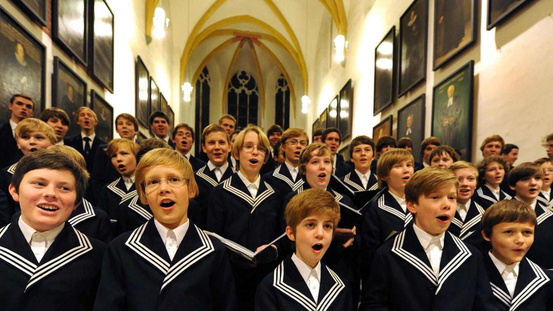 Mitglieder des Thomanerchores stehen in der Altarnische der Thomaskirche und singen mit Inbrunst. Mitglieder des Thomanerchores stehen in der Altarnische der Thomaskirche und singen mit Inbrunst.
