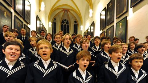 Mitglieder des Thomanerchores stehen in der Altarnische der Thomaskirche und singen mit Inbrunst.