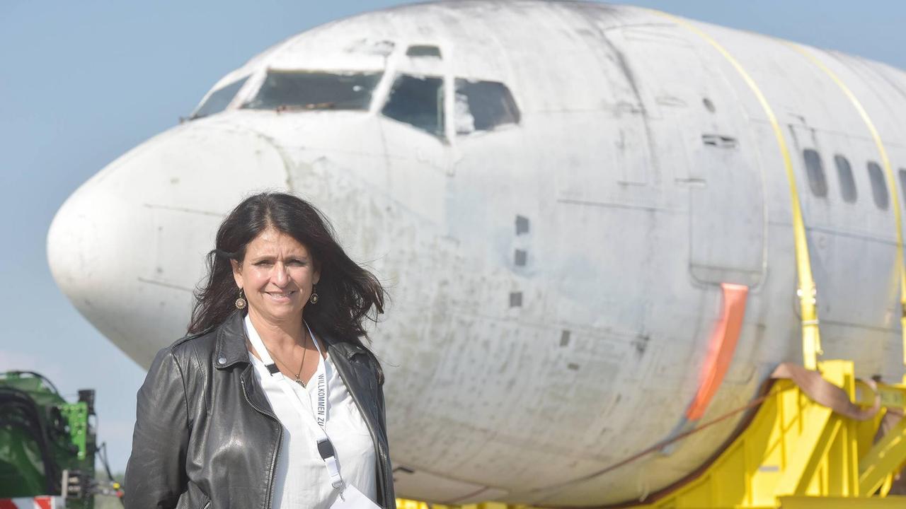 Diana Müll steht im Freien vor einer sichtlich alten Lufthansa-Maschine. Diana Müll steht im Freien vor einer sichtlich alten Lufthansa-Maschine.