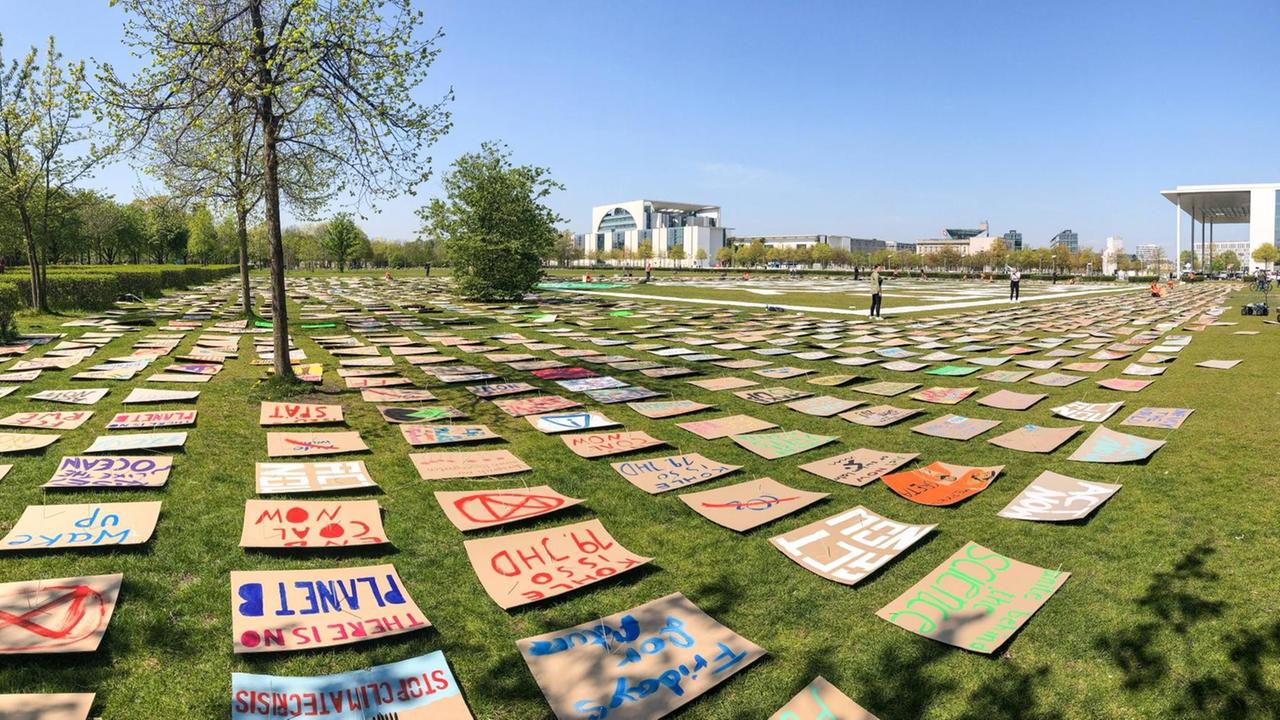 Viele bemalte Schilder liegen auf der Wiese vor dem Bundestag in Berlin. Viele bemalte Schilder liegen auf der Wiese vor dem Bundestag in Berlin.