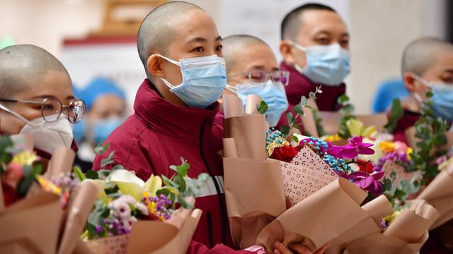 Chinesische Mitglieder eines medizinischen Einsatzteams im Kampf gegen das Coronavirus. Sie haben sich extra für den Schutzanzug die Haare abrasieren lassen.