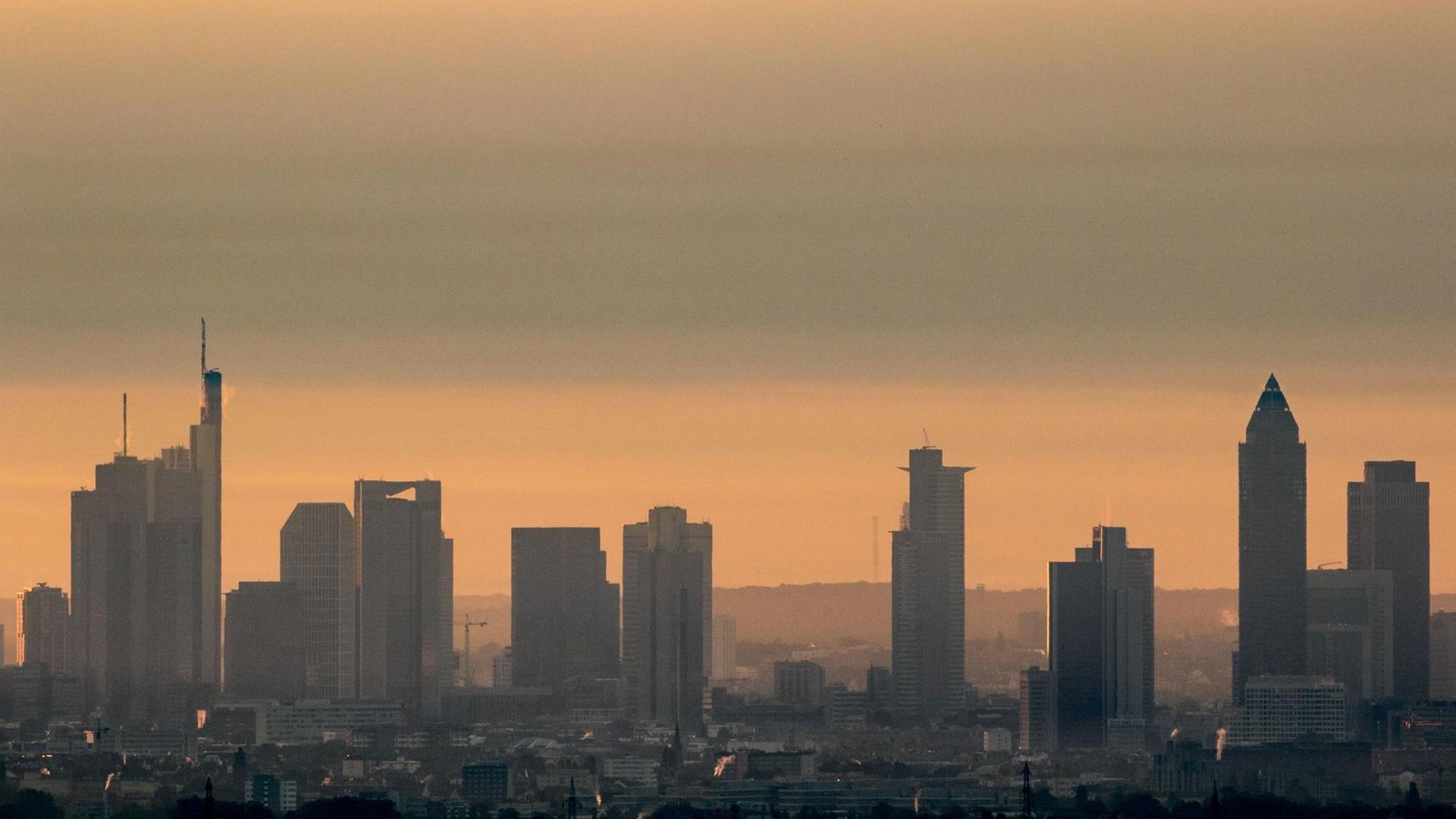 Die Hochhäuser von Frankfurt am Main (Hessen) sind im Licht der aufgehenden Sonnen im morgendlichen Dunst beim Blick von Kronberg im Taunus zu sehen. Die Hochhäuser von Frankfurt am Main (Hessen) sind im Licht der aufgehenden Sonnen im morgendlichen Dunst beim Blick von Kronberg im Taunus zu sehen.