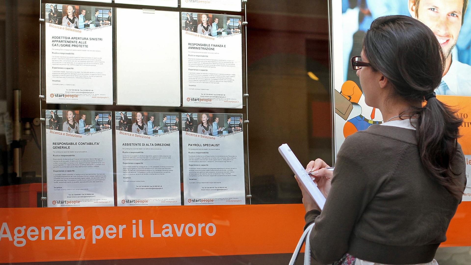 Eine junge Frau studiert in Mailand Stellenanzeigen.