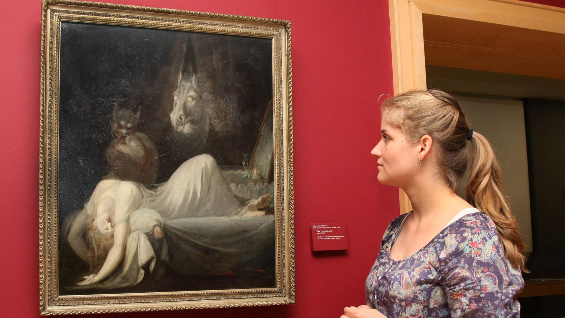 Eine Besucherin betrachtet am 22.05.2012 in der Gemäldegalerie des Goethehauses in Frankfurt am Main das Gemälde Der Nachtmahr von Johann Heinrich Füssli (um 1790/91). Eine Besucherin betrachtet am 22.05.2012 in der Gemäldegalerie des Goethehauses in Frankfurt am Main das Gemälde Der Nachtmahr von Johann Heinrich Füssli (um 1790/91).