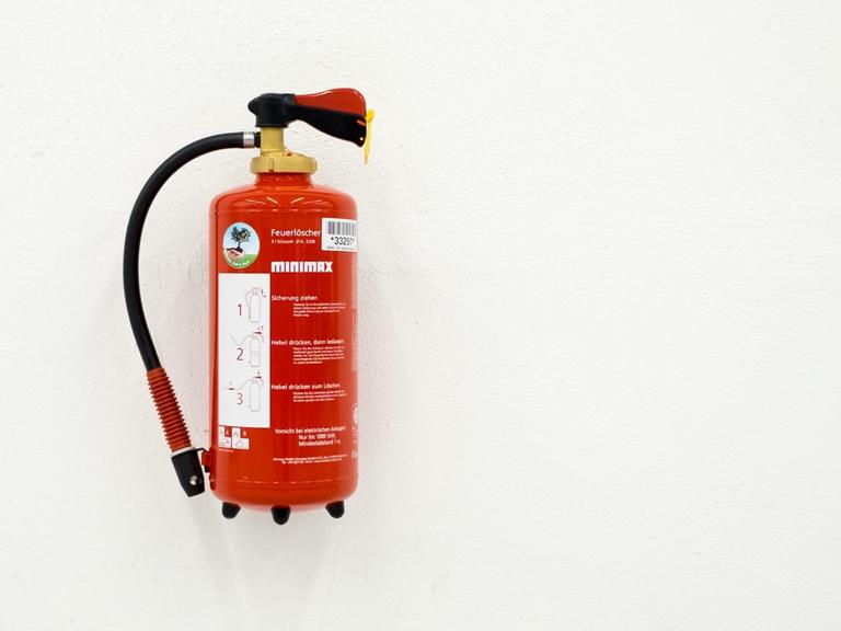 Roter Feuerlöscher an einer weißen Wand
