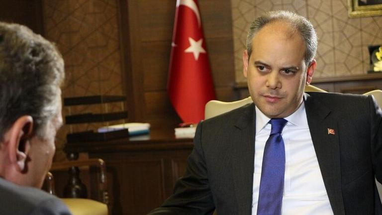 Der türkische Sportminister Akif Kilic sitzt auf einem Sessel, im Hintergrund die türkische Flagge, ihm gegenüber Michel Friedman, von dem nur der Hinterkopf zu sehen ist. Der türkische Sportminister Akif Kilic sitzt auf einem Sessel, im Hintergrund die türkische Flagge, ihm gegenüber Michel Friedman, von dem nur der Hinterkopf zu sehen ist.
