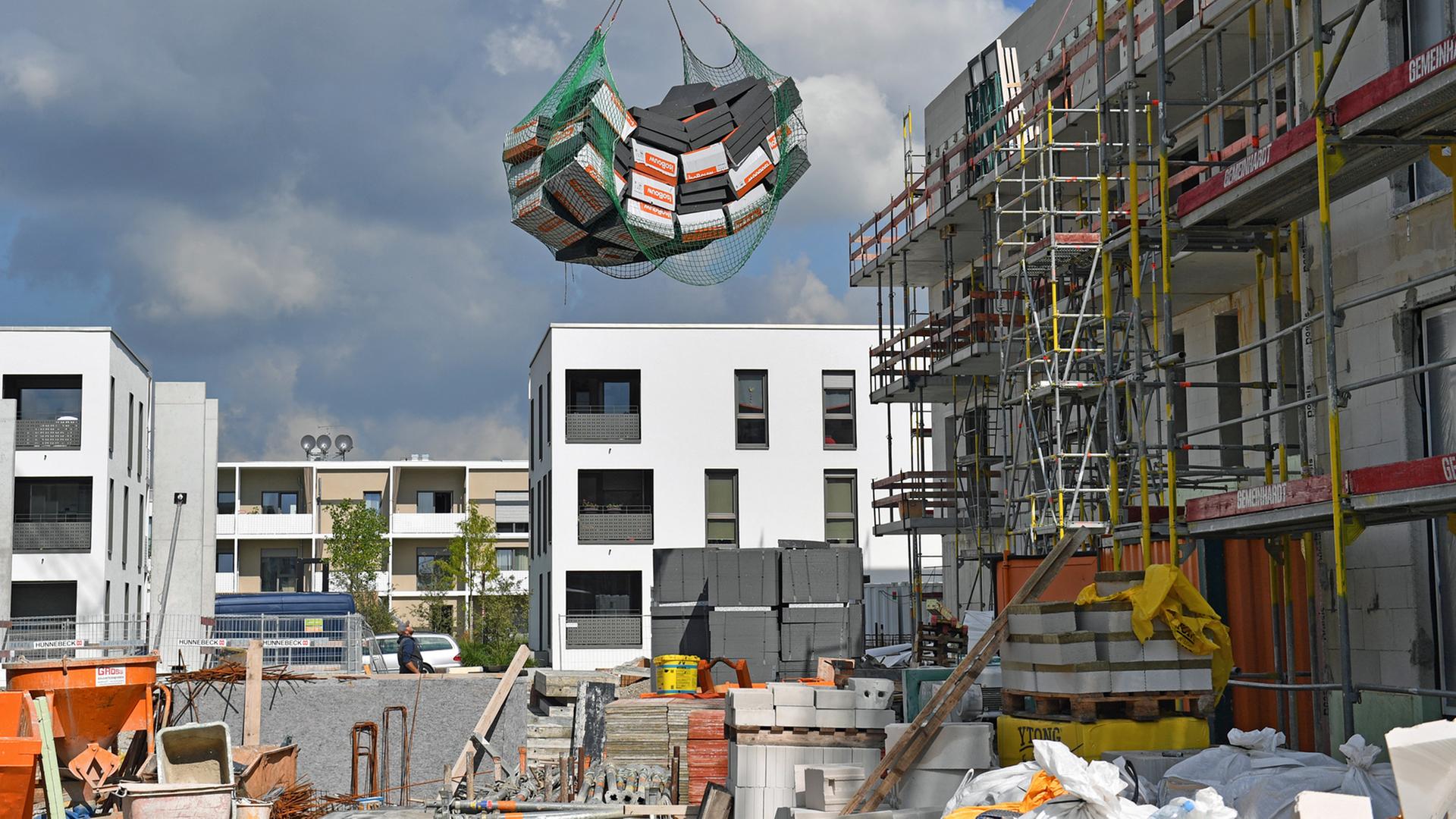 Wohnungsbau in München: Dämmplatten werden über eine Baustelle gehoben.