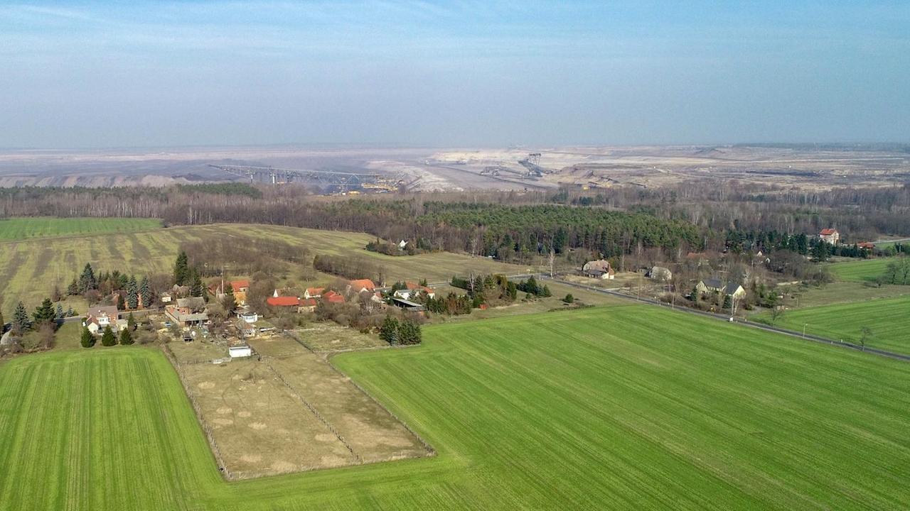 Eine Luftaufnahme auf das brandenburgisches Dorf Proschim, im Hintergrund ist eine riesige Braunkohlegrube zu sehen. Eine Luftaufnahme auf das brandenburgisches Dorf Proschim, im Hintergrund ist eine riesige Braunkohlegrube zu sehen.