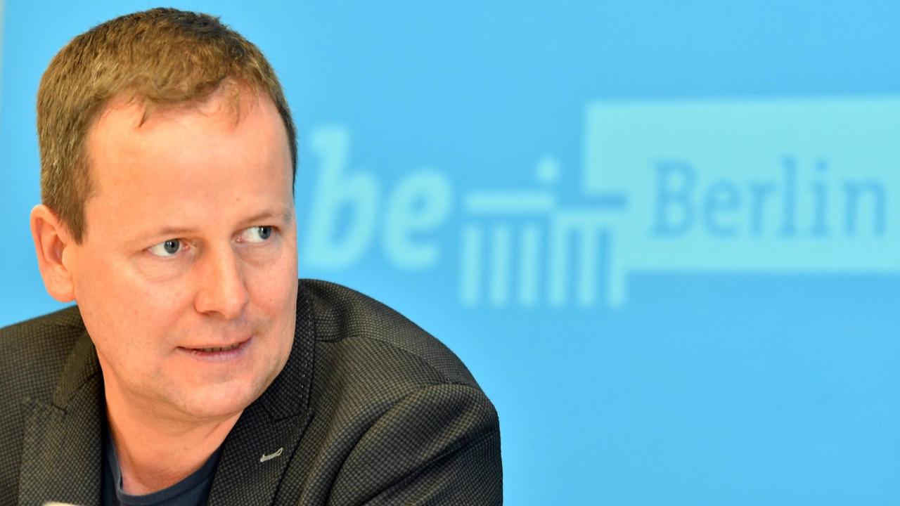 Berlins Kultursenator Klaus Lederer vor einer blauen Wand mit dem Logo des Berliner Senats. Berlins Kultursenator Klaus Lederer vor einer blauen Wand mit dem Logo des Berliner Senats.