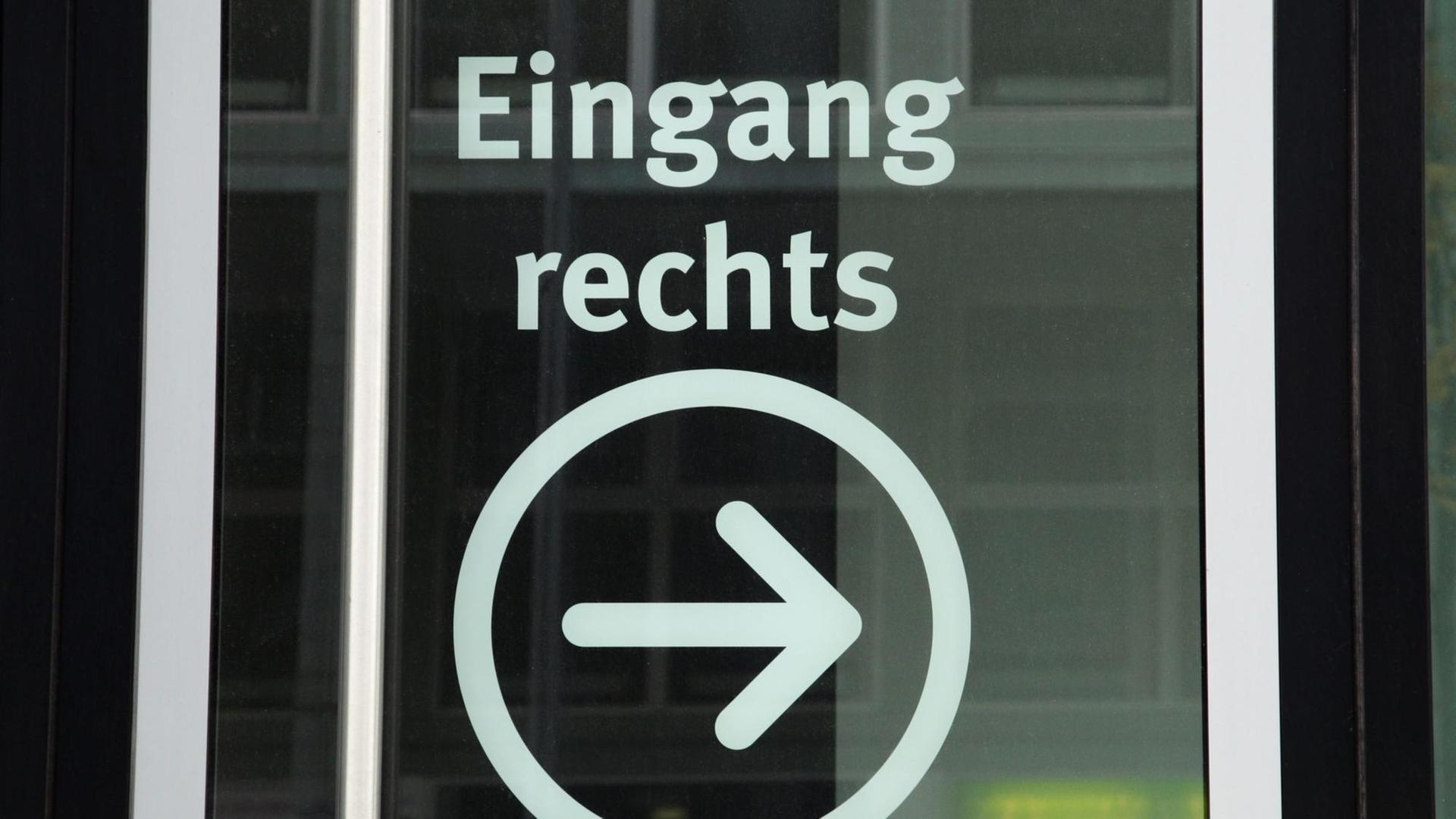Auf einer Glastür steht "Eingang rechts" mit einem eingekreisten Pfeil Auf einer Glastür steht "Eingang rechts" mit einem eingekreisten Pfeil