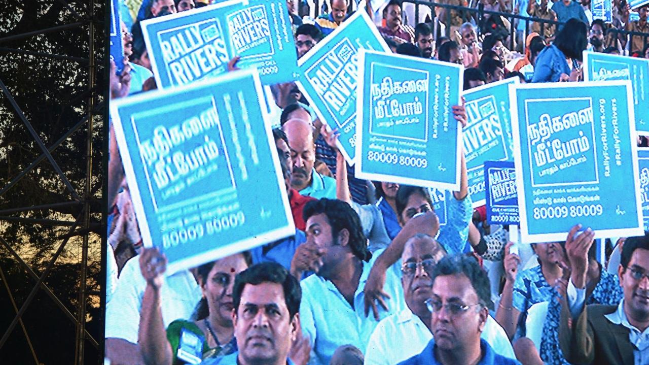 Das Publikum der "Rally for Rivers"-Kampagne im Südindischen Chennai hält Schilder hoch.