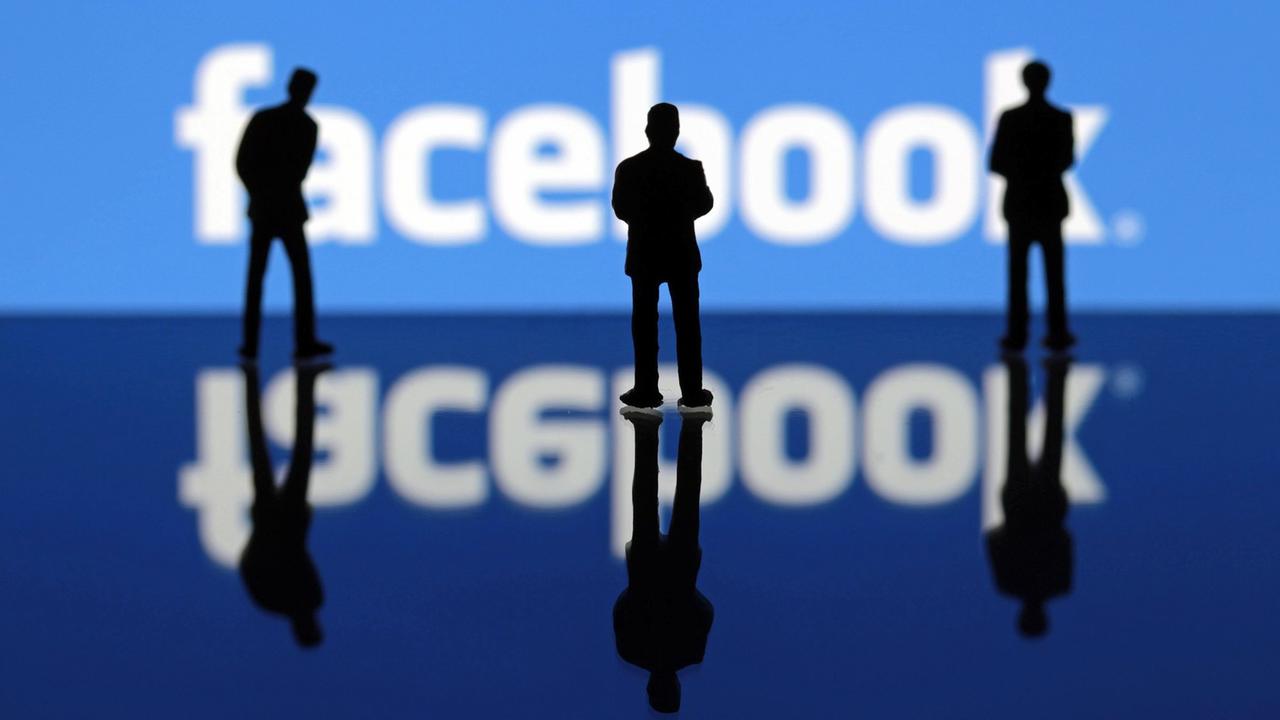 Miniatur Figuren stehen vor dem Facebook-Logo
Miniatur Figuren stehen vor dem Facebook-Logo