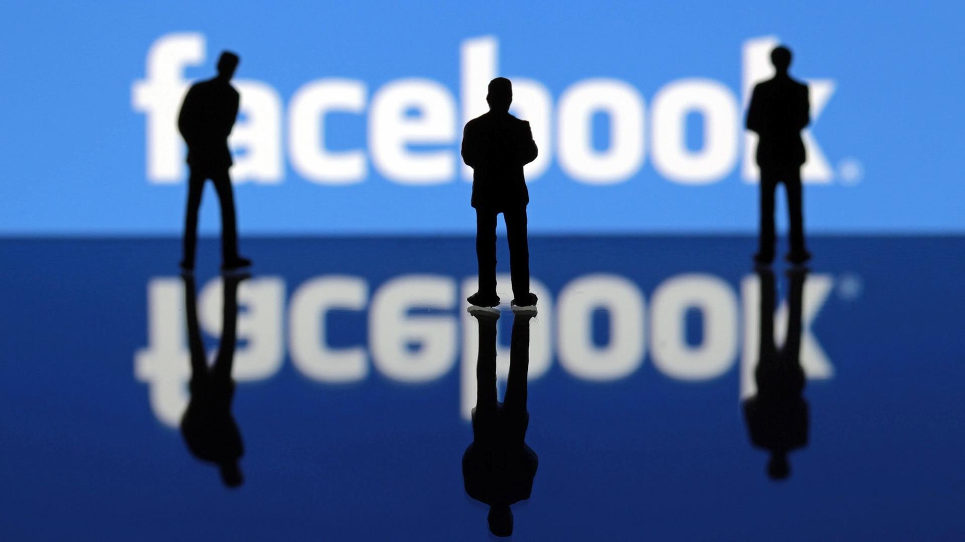Miniatur Figuren stehen vor dem Facebook-Logo Miniatur Figuren stehen vor dem Facebook-Logo