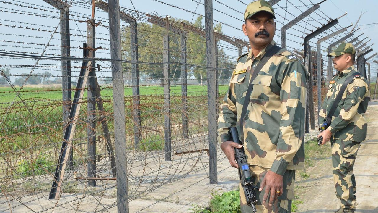 Zwei bewaffnete indische Soldaten an einem Grenzzaun zwischen Indien und Pakistan in der Region Amritsar. Zwei bewaffnete indische Soldaten an einem Grenzzaun zwischen Indien und Pakistan in der Region Amritsar.