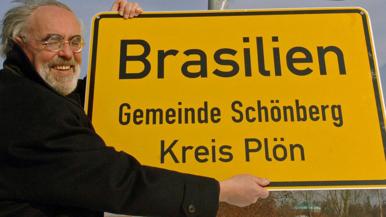 Wilfried Zurstraßen, damals Bürgermeister, präsentiert am 9.3.2006 das Ortsschild von Brasilien in der Gemeinde Schönberg in Schleswig-Holstein.