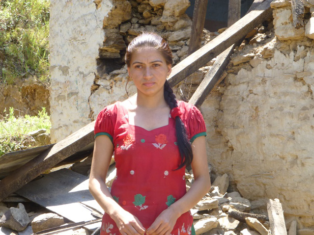 Sarita vor ihrem zerstörten Haus, für dessen Wiederaufbau nun das Geld benötigt wird, mit dem ihre Familie ihr Studium finanzierte.