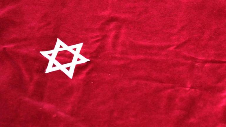 Der Davidstern, Symbol des Judentums - auf einer Samtdecke, mit der in einer Synagoge der Tisch für die Torarolle bedeckt wird Der Davidstern, Symbol des Judentums - auf einer Samtdecke, mit der in einer Synagoge der Tisch für die Torarolle bedeckt wird