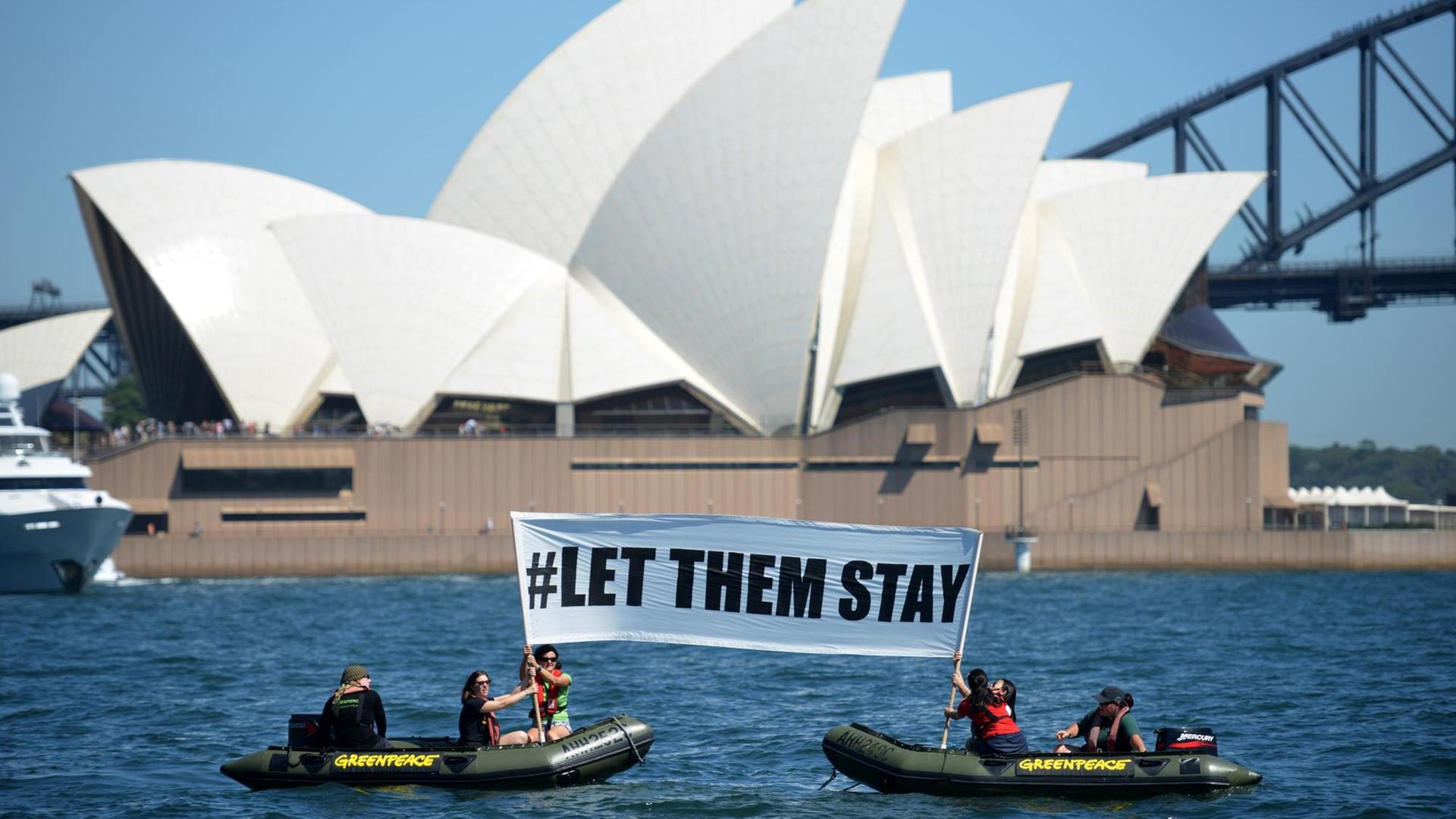 Mitglieder von Greenpeace halten ein Schild mit der Aufschrift "Let them stay" ("Lasst sie bleiben") vor dem Opernhaus in Sydney in die Höhe Mitglieder von Greenpeace halten ein Schild mit der Aufschrift "Let them stay" ("Lasst sie bleiben") vor dem Opernhaus in Sydney in die Höhe