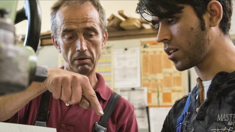 Ausbilder unterhält sich mit einem afghanischen Flüchtling. Ausbilder unterhält sich mit einem afghanischen Flüchtling.
