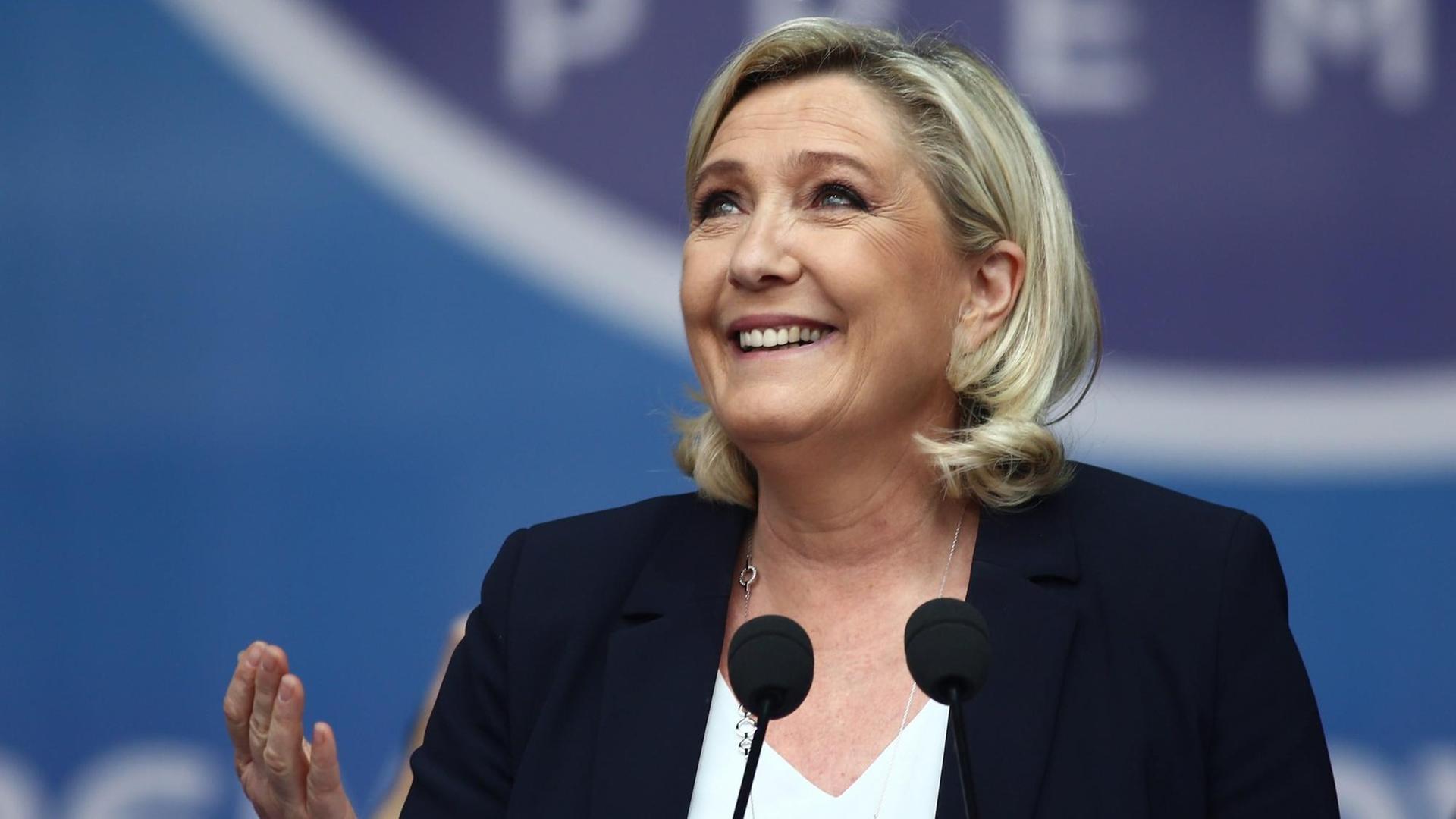 Porträt der französischen Rechtspopulistin Marine Le Pen während einer Rede vor einem Mikrofon.