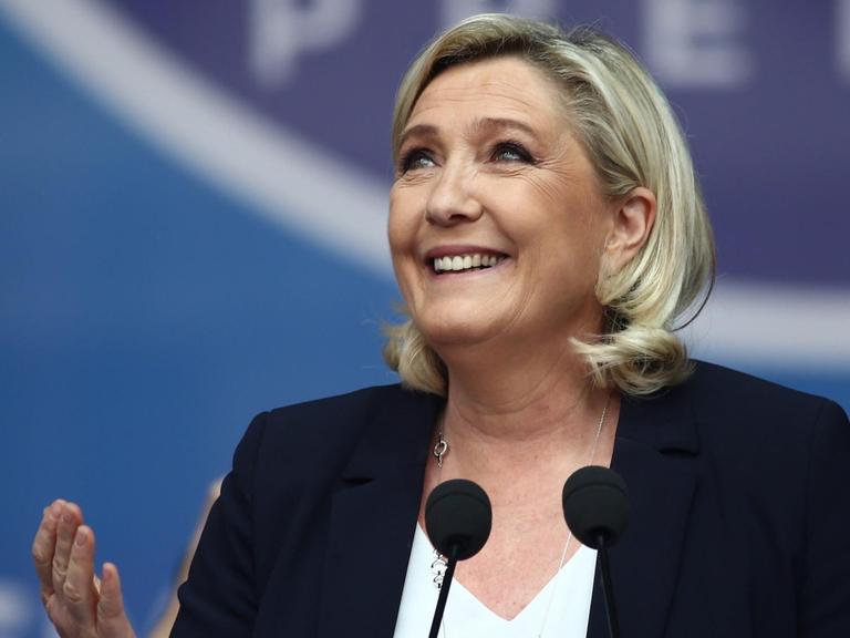 Porträt der französischen Rechtspopulistin Marine Le Pen während einer Rede vor einem Mikrofon.