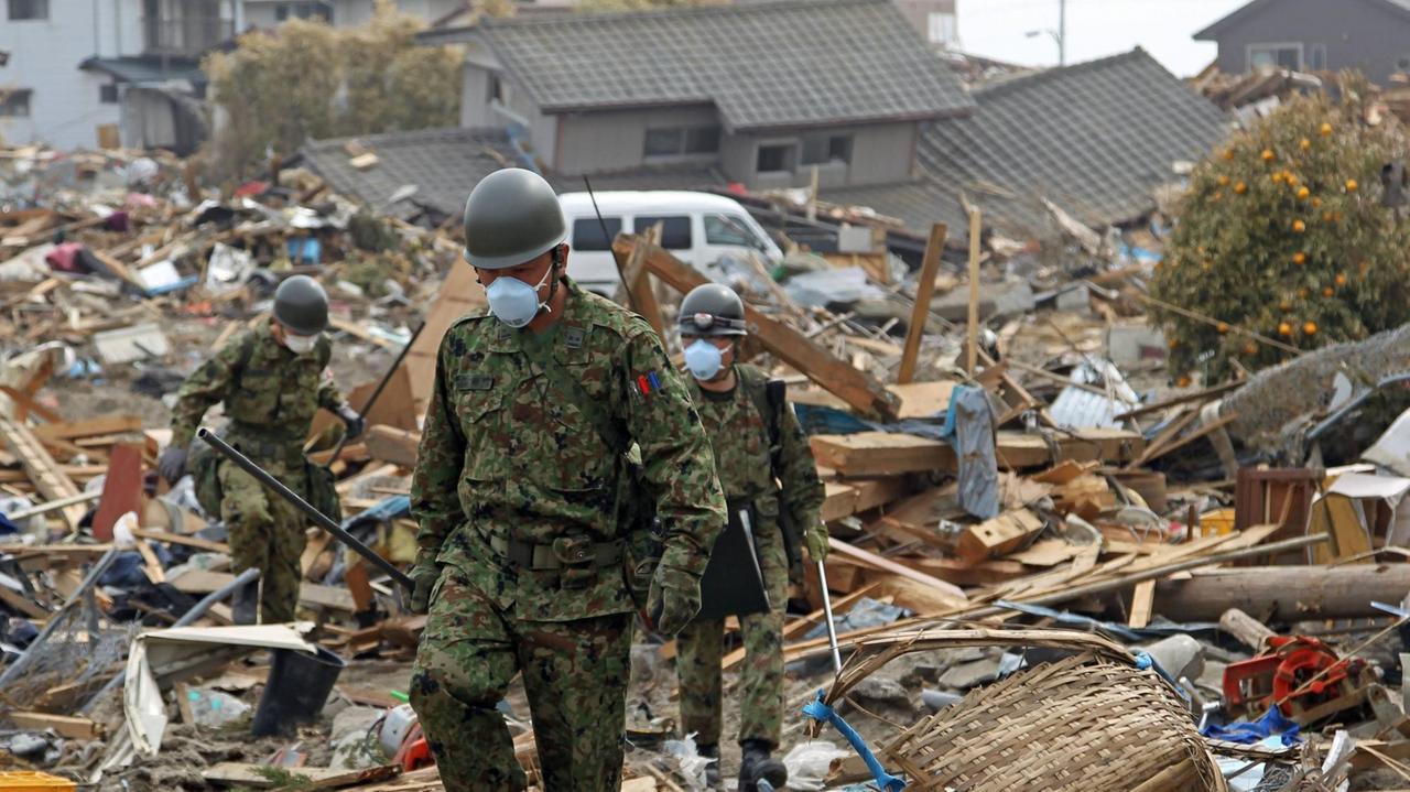Mitglieder der japanischen Selbstverteidigungsstreitkräfte suchen am 2. April 2011, wenige Tage nach dem heftigsten Erdbeben in der Geschichte Japans, in Iwaki, einer Großstadt in der Präfektur Fukushima, nach Überlebenden Mitglieder der japanischen Selbstverteidigungsstreitkräfte suchen am 2. April 2011, wenige Tage nach dem heftigsten Erdbeben in der Geschichte Japans, in Iwaki, einer Großstadt in der Präfektur Fukushima, nach Überlebenden