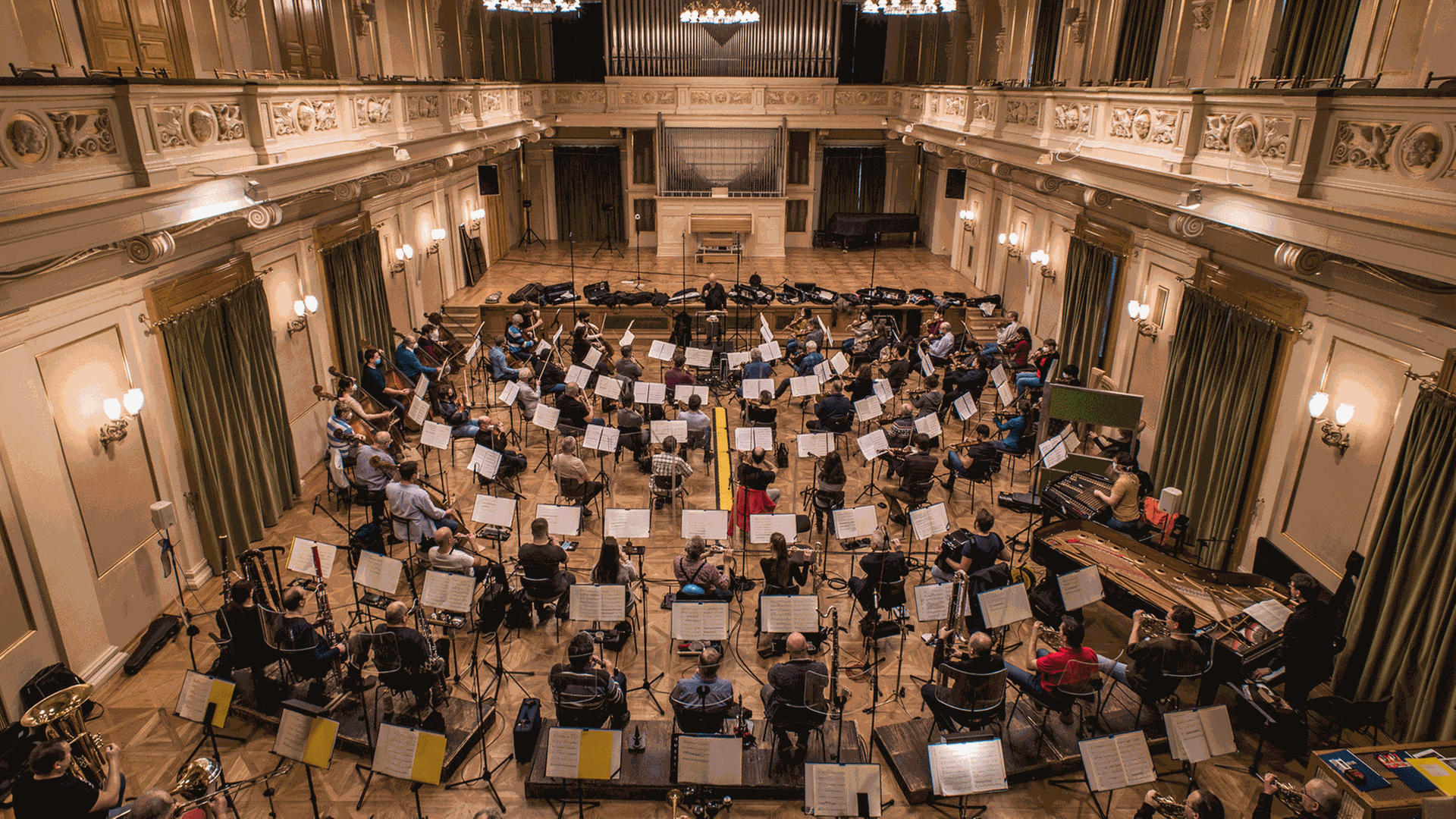 Ein einem Klassizistischen Bau sitzt des Orchester im ausgeräumten Zuschauerraum, um den Musikern genügend Platz für Abstände zu geben.