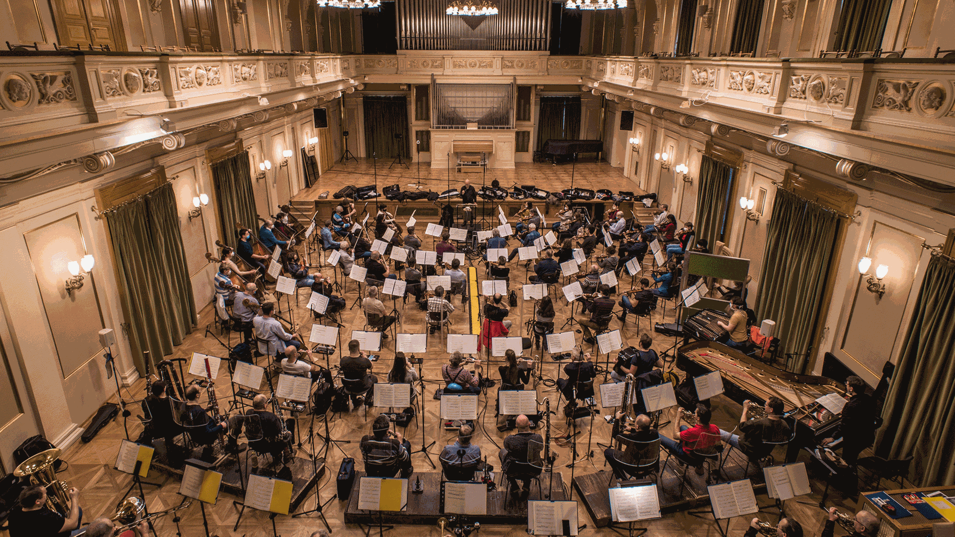Ein einem Klassizistischen Bau sitzt des Orchester im ausgeräumten Zuschauerraum, um den Musikern genügend Platz für Abstände zu geben. Ein einem Klassizistischen Bau sitzt des Orchester im ausgeräumten Zuschauerraum, um den Musikern genügend Platz für Abstände zu geben.