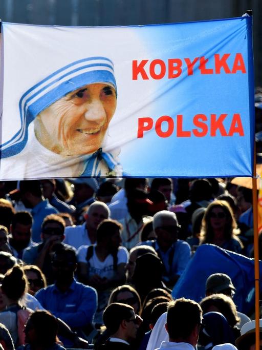 Zehntausende Menschen feiern auf dem Petersplatz in Rom die Heiliggsprechung von Mutter Teresa und halten Bilder von ihr in die Höhe.