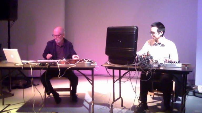 John Bischoff und James Fei geben ein Konzert. Die beiden Künstler sind für ihre Computermusik bekannt. John Bischoff und James Fei geben ein Konzert. Die beiden Künstler sind für ihre Computermusik bekannt.