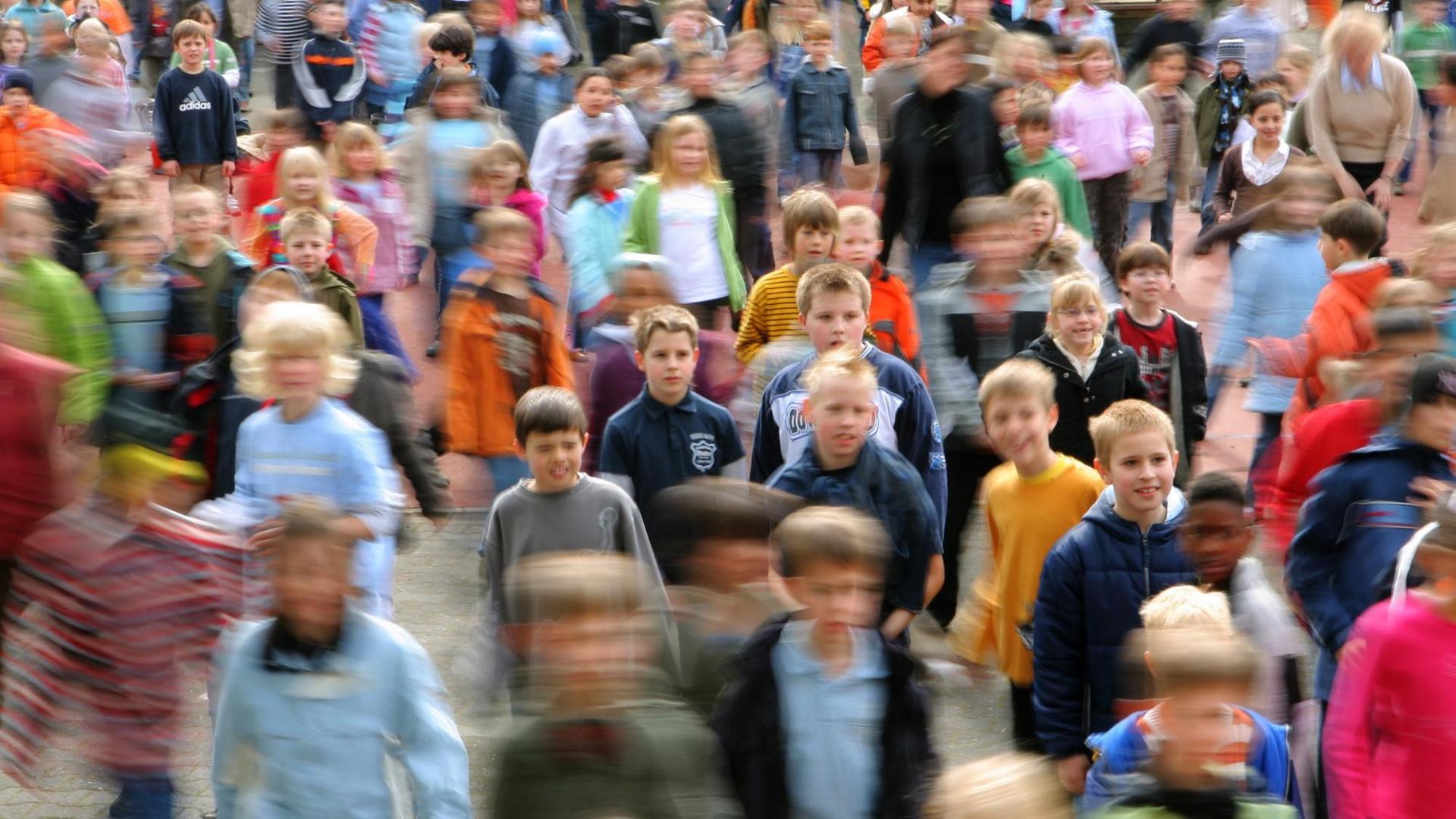 Viele Grundschülerinnen und Grundschule tanzen auf einem Schulhof. Viele Grundschülerinnen und Grundschule tanzen auf einem Schulhof.