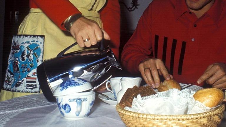 Eine Frauenhand schenkt Kaffee ein. Eine Frauenhand schenkt Kaffee ein.