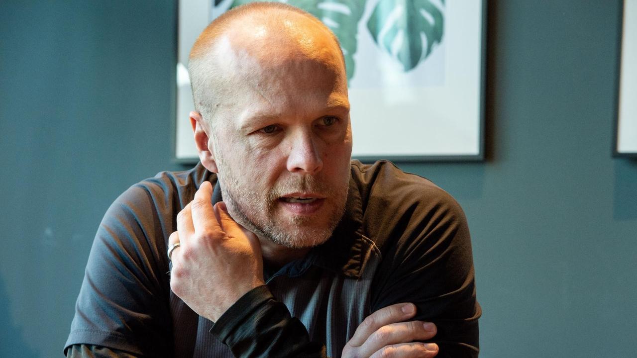 Stefan Ustorf von den Eisbären Berlin sitzt mit verschränkten Armen in einem Büro und erzählt. Stefan Ustorf von den Eisbären Berlin sitzt mit verschränkten Armen in einem Büro und erzählt.