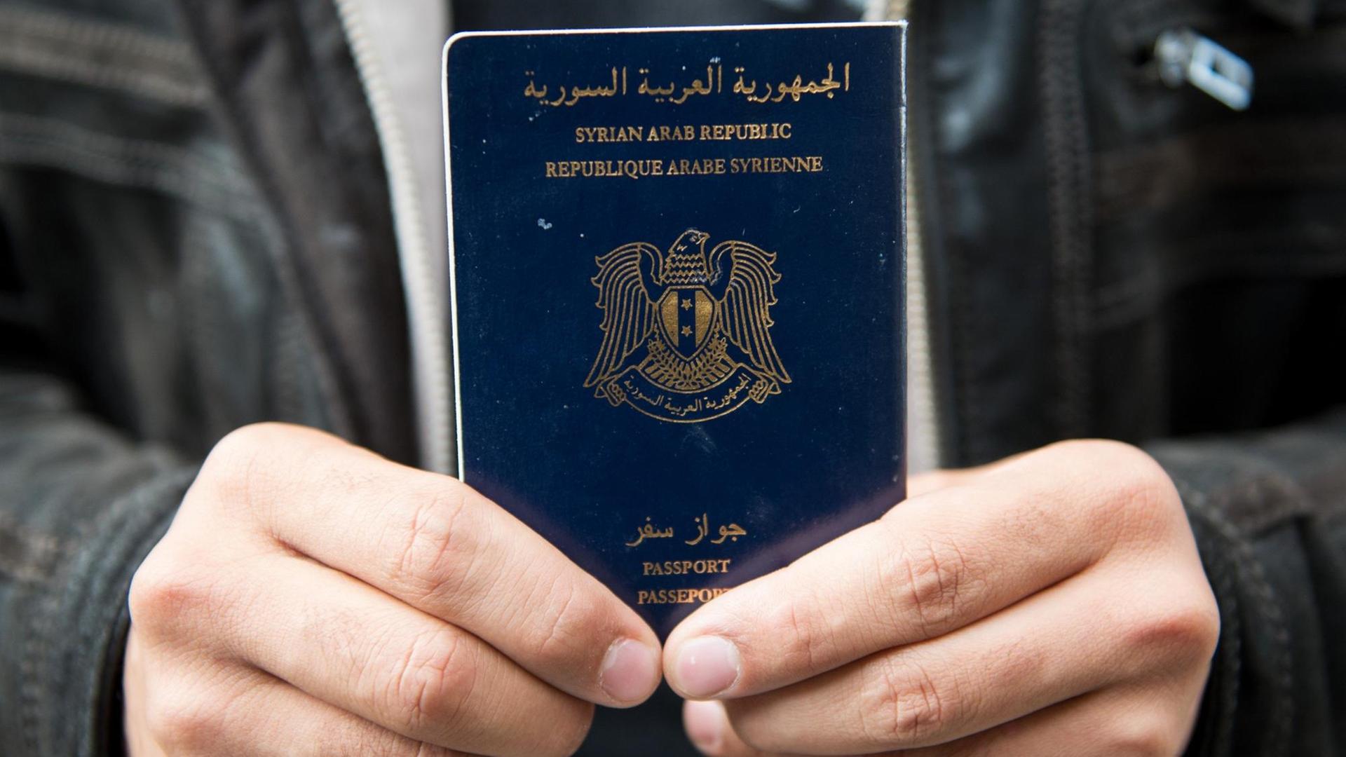 Ein Mann hält auf dem Hauptbahnhof in Lübeck (Schleswig-Holstein) einen syrischen Pass in die Kamera.