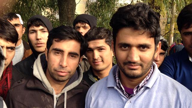 Mansur Jermal (24, l.) und Khamran Han (21), umringt von anderen jungen Männern, mit denen sie aus Afghanistan geflüchtet sind.