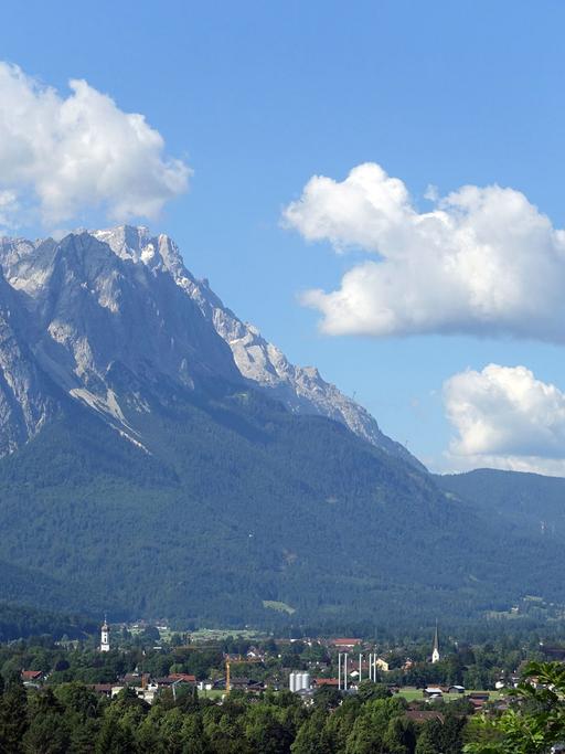 Blick auf das Wettersteingebirge mit der Zugspitze und Garmisch-Partenkirchen im Tal, aufgenommen vom Berg Wank aus.